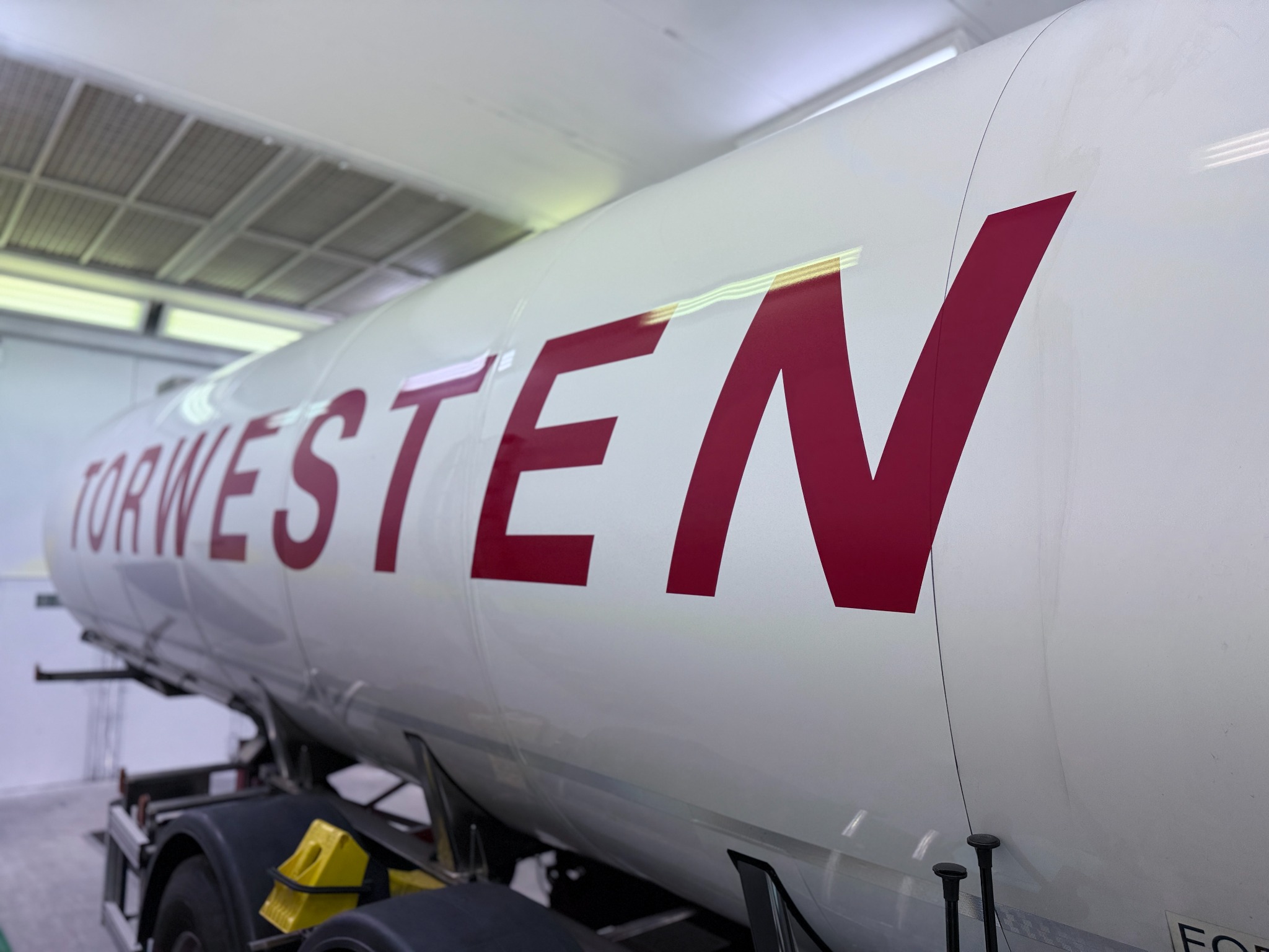 Detail einer Tankauflieger-Beschriftung in der Werkhalle
