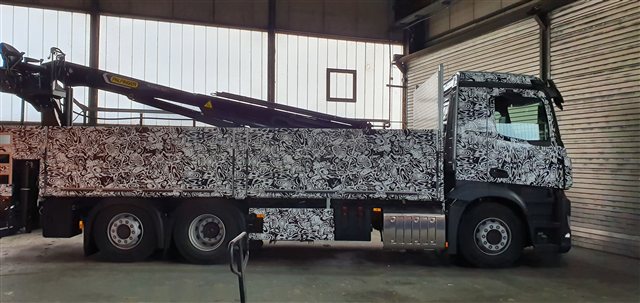 Kran-LKW mit auffälliger schwarzweißer Musterfolierung
