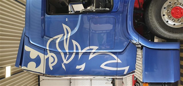Blaues LKW-Fahrerhaus mit weißer Grafik